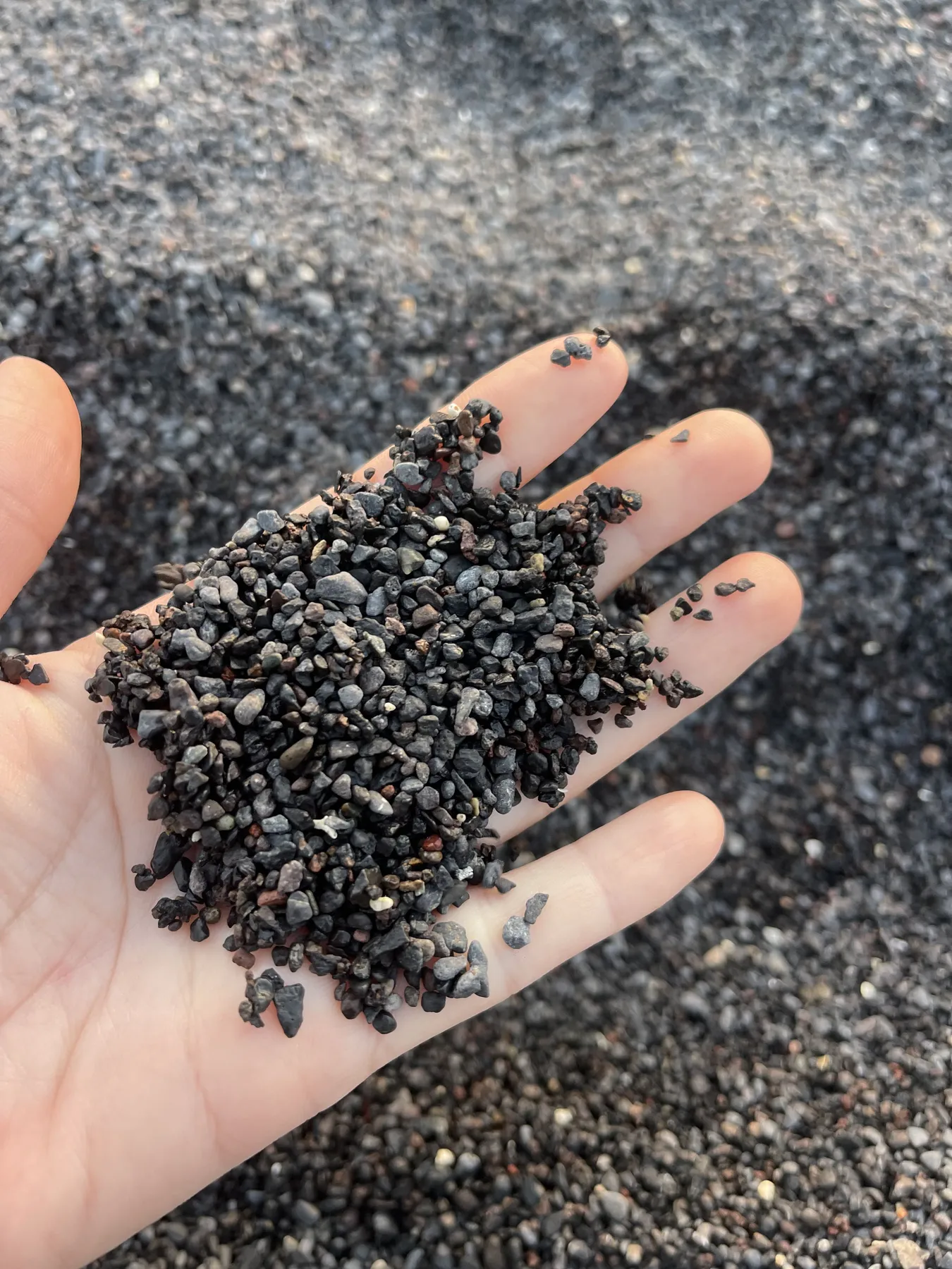 Arena volcánica negra en la palma de la mano